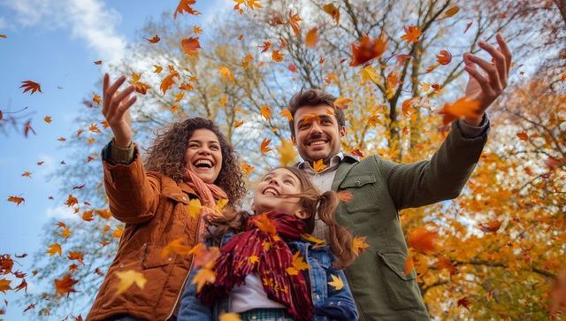 Joyful Family Tossing Autumn Leaves in Park