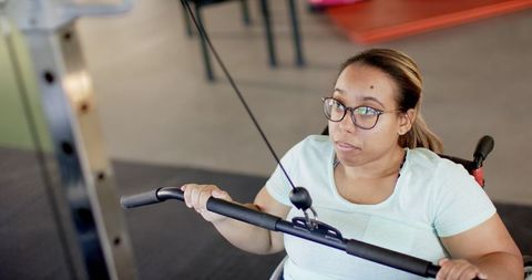 Woman in Wheelchair Strength Training with Cable Machine
