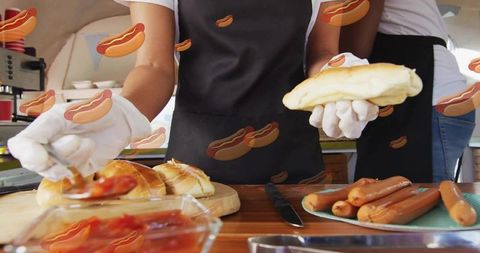 Multicultural vendors preparing hot dogs and scooping ketchup at outdoor food stall