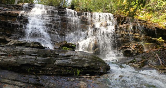 Majestic Waterfall Cascading Over Rocky Cliff in Forested Area - Download Free Stock Images Pikwizard.com