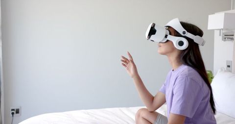 Young Woman Engaging with Virtual Reality on Bed