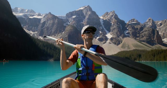 Man Kayaking on Crystal Clear Lake with Mountain View - Download Free Stock Photos Pikwizard.com