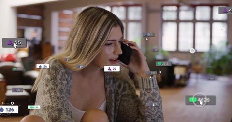 Talking woman holding smartphone with social media notifications in living room