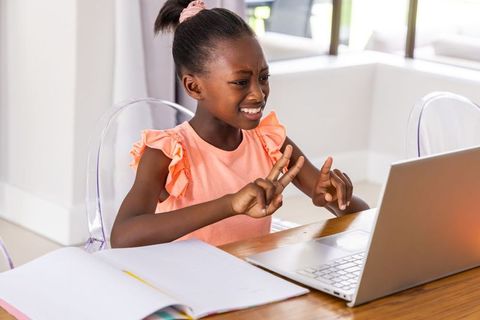 African girl studying at home using laptop for remote learning and virtual class
