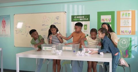 Children sorting recyclables with teacher in colorful classroom promoting sustainability