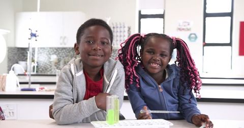 Cheerful Students Exploring Science Lab with Test Tubes