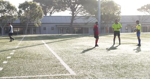 Teen soccer players practicing on sunny grass field