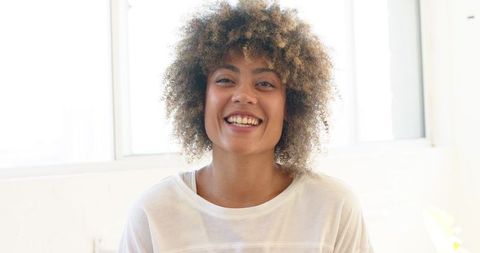 Smiling Woman Enjoying Bright Minimalist Studio Ambiance