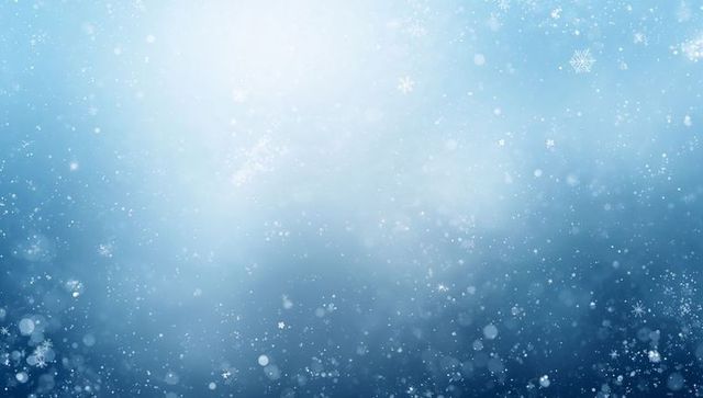Drifting snowflakes and soft bokeh on blue winter gradient glow