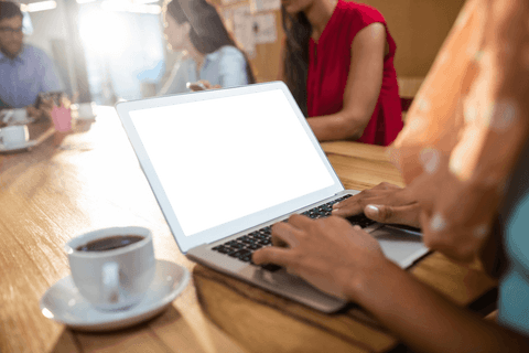 Businesswoman typing on laptop with blank screen in office setting