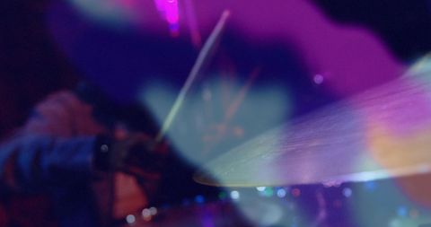 Blurry lights over musician playing drums in vibrant colors