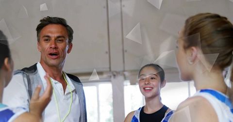 Sports Instructor Coaching Young Gymnasts in Gymnasium