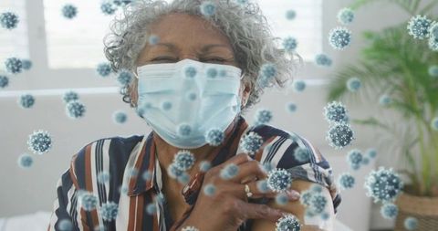 Senior woman receiving vaccine while wearing surgical mask with virus overlay visuals