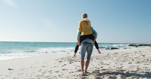 Happy Couple Piggybacking on Sandy Beach