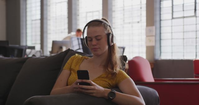 Young Woman Listening to Music with Headphones in Modern Office - Download Free Stock Images Pikwizard.com