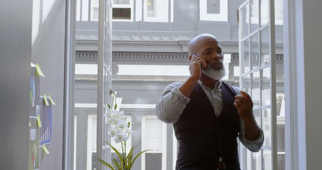 Confident Businessman Talking on Phone in Bright Office - Download Free Stock Images Pikwizard.com