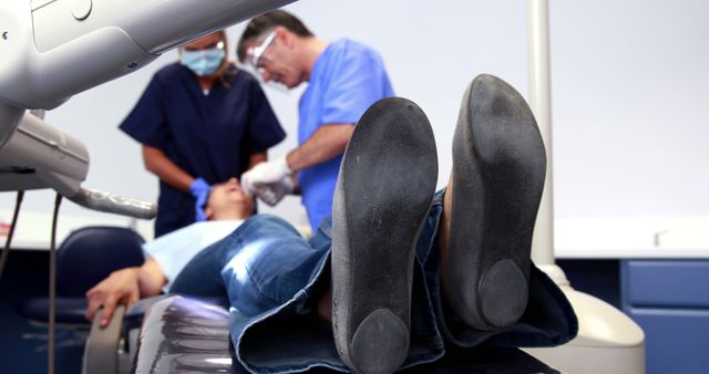 Patient in Dental Exam Chair Receiving Treatment from Dentist - Download Free Stock Images Pikwizard.com