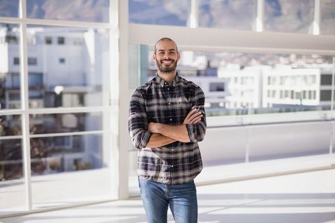 Confident Professional Standing in Modern Office with City View