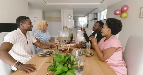 Happy Friends Enjoying Meal and Drinks at Home