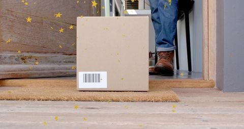 Sitting cardboard parcel on coir doormat with barcode, confetti and rolled jeans boots