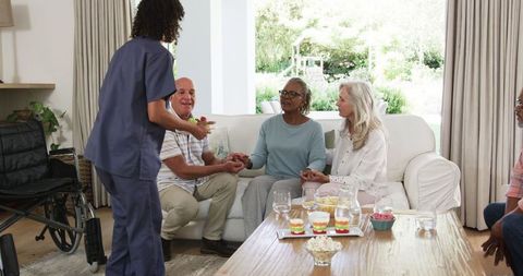 Seniors engaging in lively conversation over snacks in cozy living room