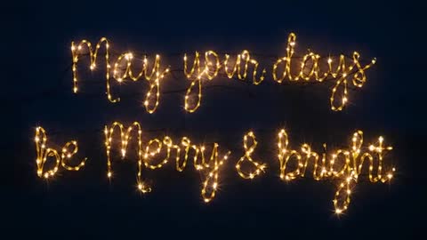 Looping scripted LED fairy lights spelling May your days be Merry & Bright over dark backdrop