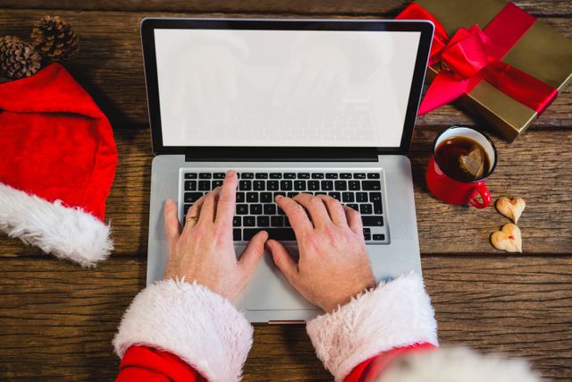 Santa Claus using laptop on table 
