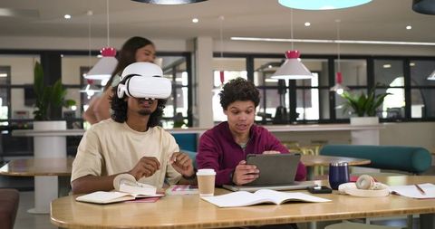African American Students Testing VR Headset While Studying with Tablet in Campus Commons