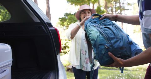 Senior couple packing car for outdoor travel adventure