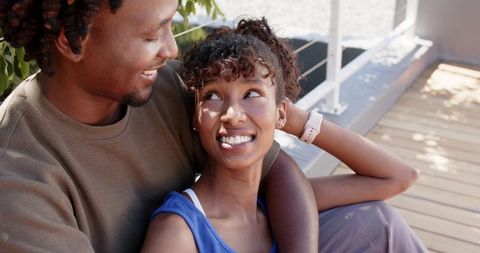 African american couple sharing affectionate rooftop embrace smiling and relaxing on deck