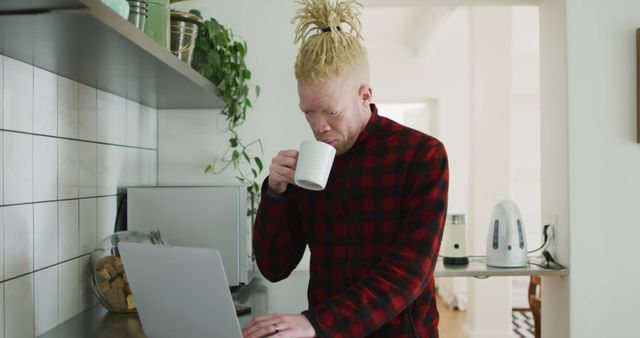 Young Man Drinking Coffee While Using Laptop at Home in Kitchen - Download Free Stock Images Pikwizard.com