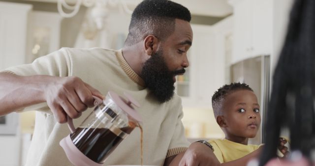 Father Pouring Coffee at Kitchen Table While Watching Toddler - Download Free Stock Images Pikwizard.com