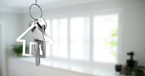 Key with house shaped keychain in modern kitchen setting