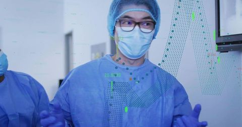 Surgical team member wearing gown mask gloves viewing monitor showing digital data overlays