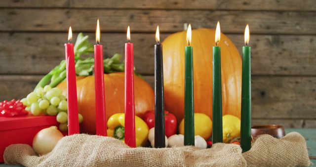 Composition of seven lit candles and halloween pumpkins and vegetables. halloween tradition and celebration concept digitally generated image.