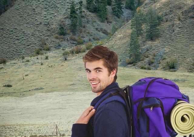 Happy man carrying backpack, smiling in front of a scenic mountain landscape. Ideal for travel blogs, adventure gear promotions, lifestyle articles focusing on outdoor activities, and social media content about hiking adventures.