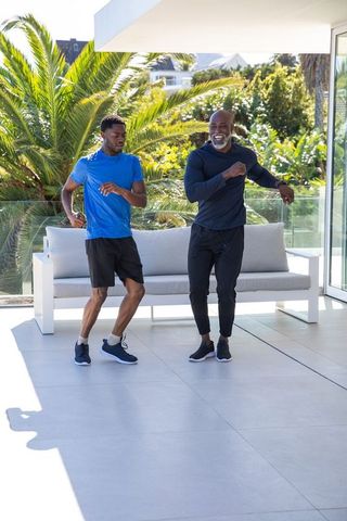 Senior Father and Son Bonding Through Dance on Patio