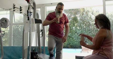 Senior couple exercising at home gym with positive encouragement