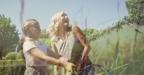Mother and Daughter Enjoying Tennis on Sunny Day