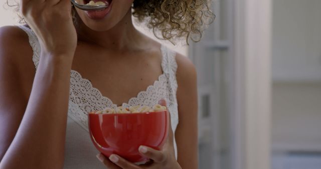 Close-Up of Woman Eating Cereal from Red Bowl in Kitchen - Download Free Stock Images Pikwizard.com