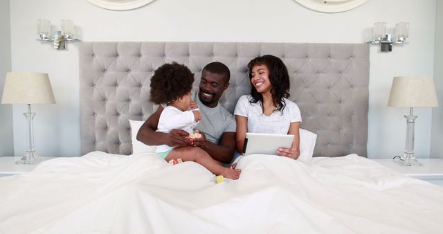 Smiling Family Relaxing in Bed Sharing Time Together - Download Free Stock Images Pikwizard.com