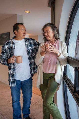 Senior Couple Enjoying Coffee Near Arched Window in Modern Home