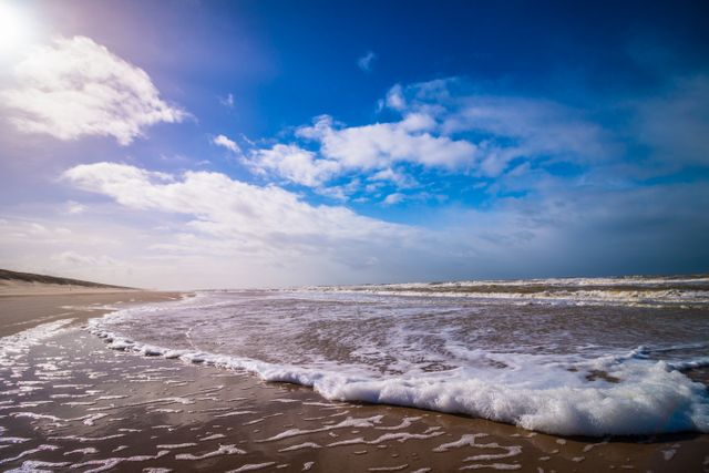 Rising Tide Under Bright Blue Sky on Sandy Beach - Download Free Stock Photos Pikwizard.com