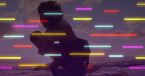 Couple Enjoying Piggyback Ride on Sunset Beach with Neon Light Streaks and Silhouette