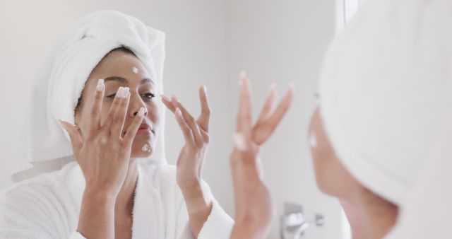 Biracial Woman Applying Face Cream in Bathroom for Self Care Routine - Download Free Stock Images Pikwizard.com