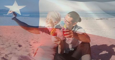 Senior couple toasting on beach with cocktails