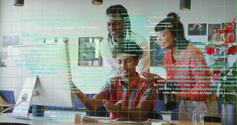 Team reviewing code at desktop with green grid overlay in open modern workspace