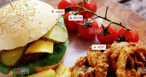 Serving sesame burger with pickles, cheddar, fries and crispy onion rings on wood board