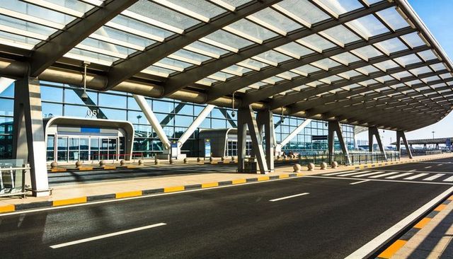 Contemporary airport curbside canopy with glass facade and v-shaped structural columns