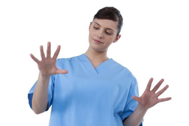 This image depicts a female doctor in blue scrubs interacting with a virtual interface. Ideal for illustrating modern medical technology, healthcare innovation, and digital interaction in medical settings. Suitable for use in healthcare websites, medical technology promotions, and educational materials about modern medicine.